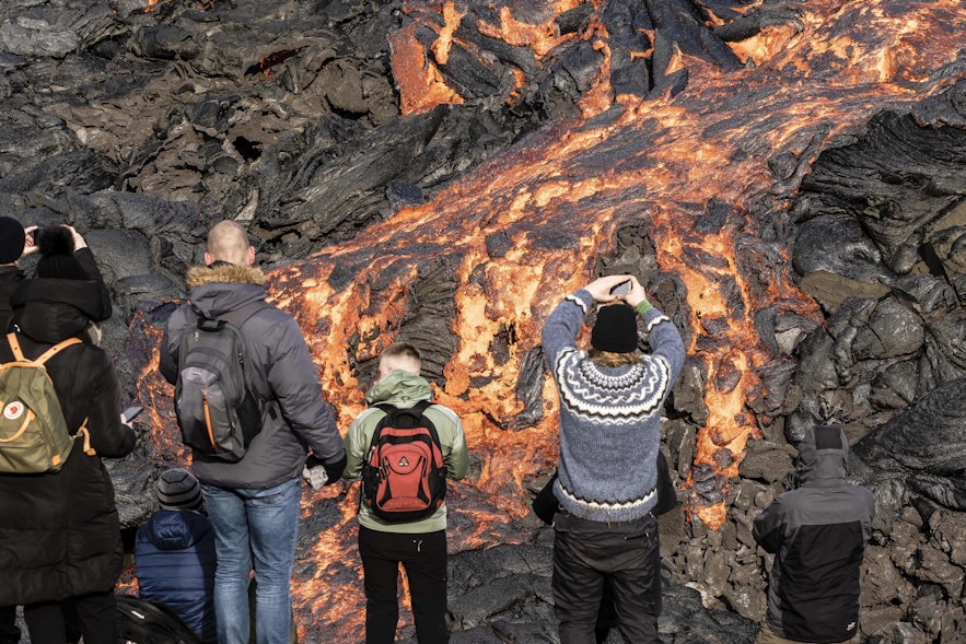 Vulkanische Spalteneruption am Berg Fagradalsfjall nahe der Ortschaft Grindavik auf der Halbinsel Reykjanes im Südwesten Islands. Die Lava fließt in das Tal Geldingadalur. Besucher können das Gebiet bereten. Die Sicherheit wird durch Rettungsteams, Wissenschaftler und Polizei gewährleistet, die das Gebiet bei Gefahr sperren.