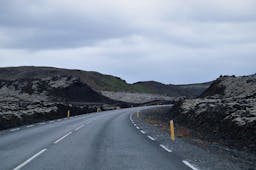 A road cuts through the moss-coated Ögmundarhraun lava field.