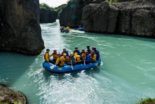 Rafts full of people float along the Hvita river and through the Bruarhlod Canyon.