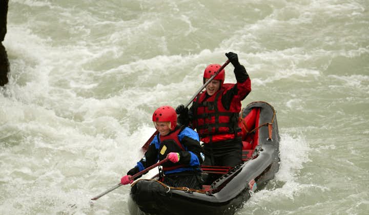 Two people in an inflatable kayak on the white water of the Hvita river.
