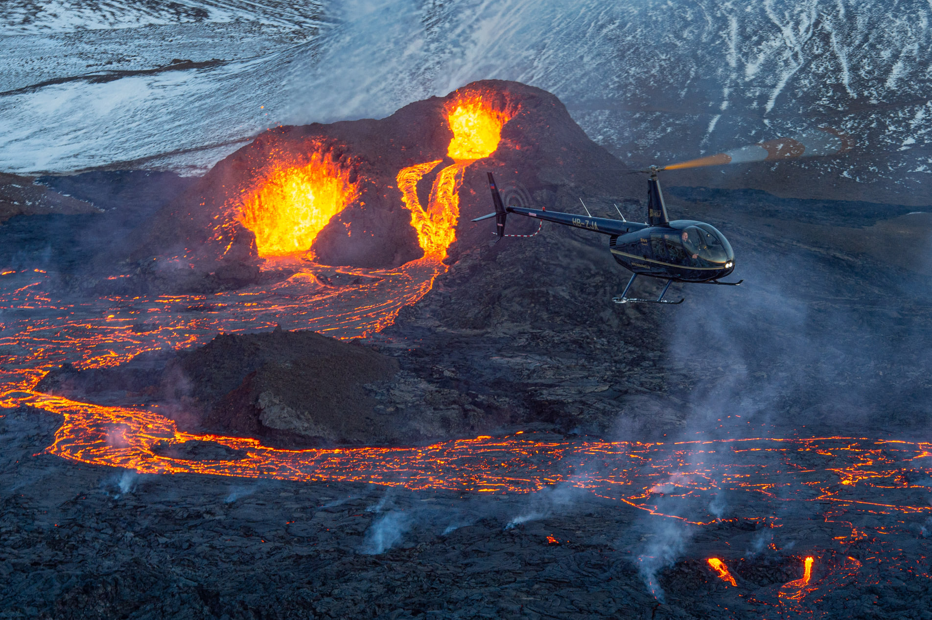 一架直升机在冰岛正在进行的火山喷发上空翱翔。
