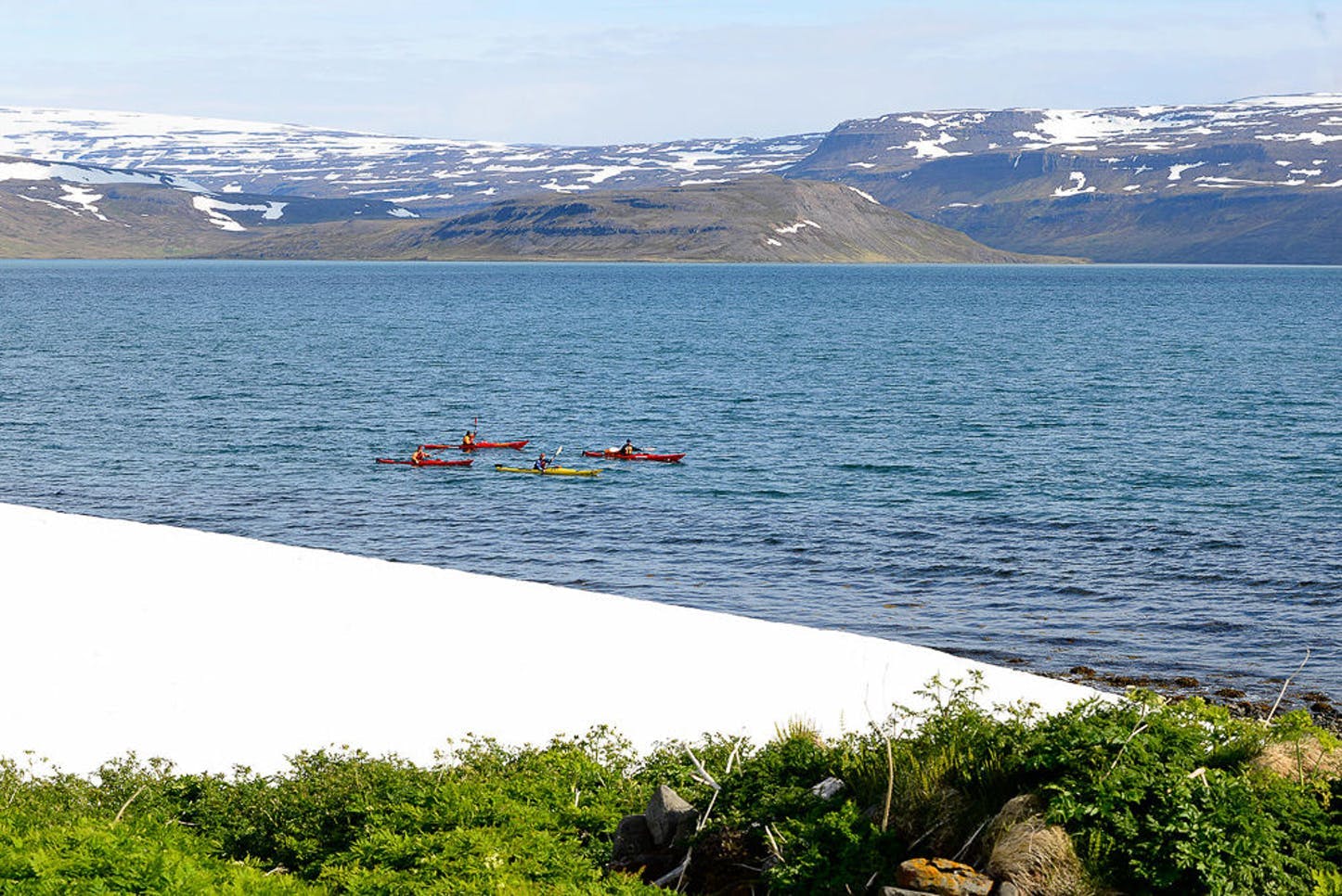 Kayaks sail past the coast of Hornstrandir.