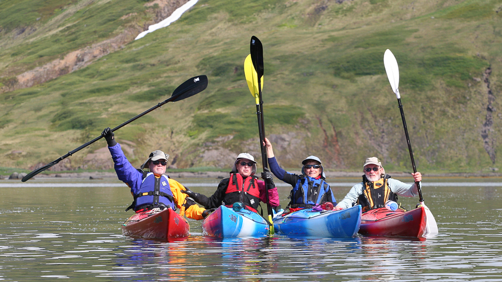 A group of kayakers celebrate their journey in Iceland.