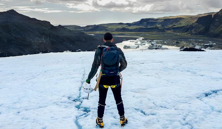 A tourist on the Solheimajokull glacier hiking tour in South Iceland enjoys a view.