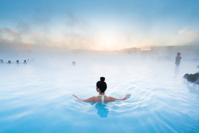 A woman relaxes in the steaming waters of the Blue Lagoon geothermal spa.