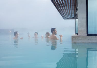 En gruppe mennesker, der bader i det dampende vand i Blå Lagune  geotermiske spa.