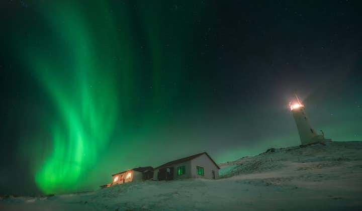 Le aurore vorticano sopra una casa in Islanda.