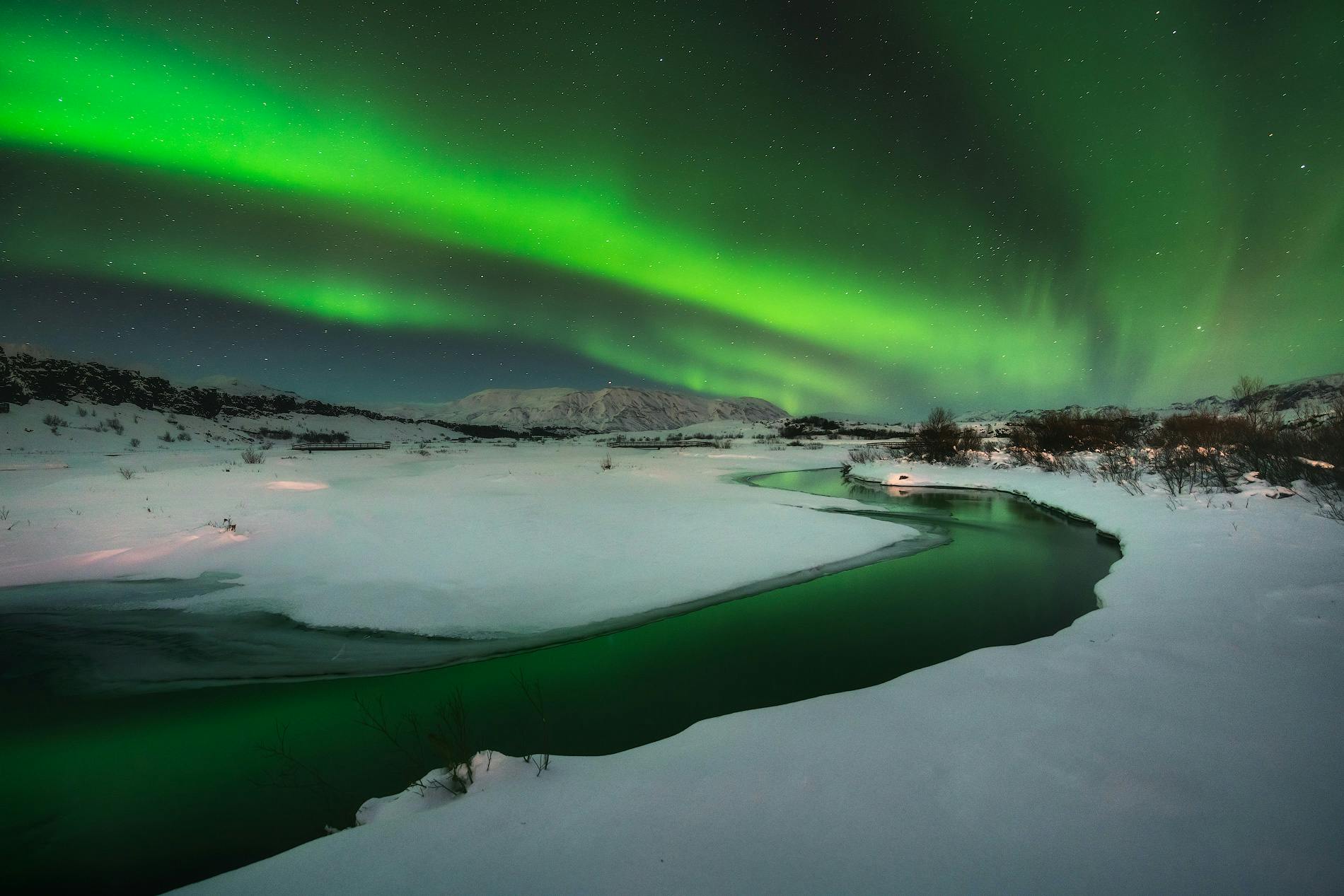 冬のアイスランドの大地を照らすオーロラ