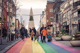 A family walking down the rainbow-painted street of Skolavordustigur, Reykjavik.