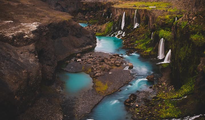 Landscape at Sigoldugljufur canyon with waterfalls and pristine blue-green water.