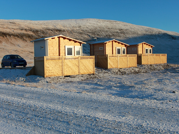 The Dalahyttur Lodges surrounded by snow in winter.