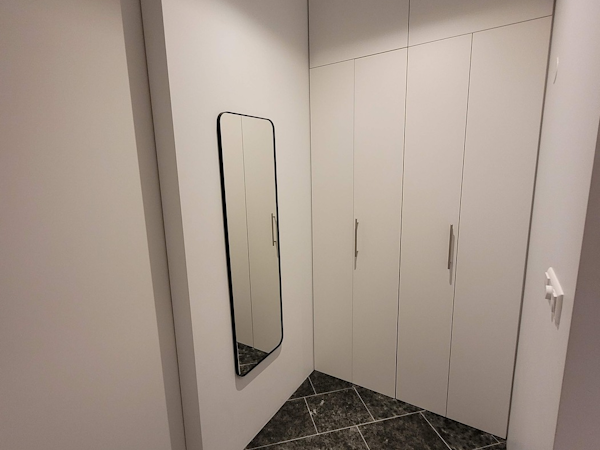 Floor to ceiling cupboards at Klettasel with a large mirror on one wall.