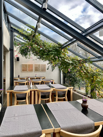 Dining space with overhead windows and greenery at Hotel Skalholt.