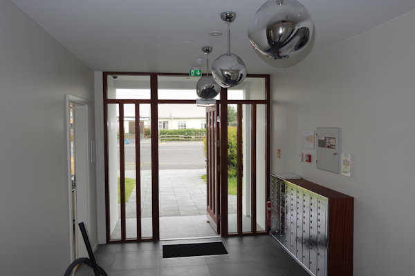 The entrance to Graystone Guesthouse with a wooden and glass door.