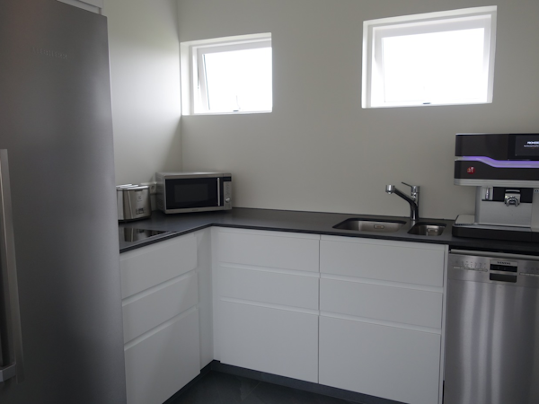 The self-catering kitchen at Graystone Guesthouse with white cupboards, kettle and microwave.