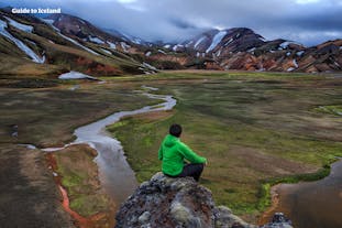 아이슬란드 남부 하이랜드 지역의 심장부에 위치한 란드만날뢰이가르를 바라보고 앉아 있는 여행객.