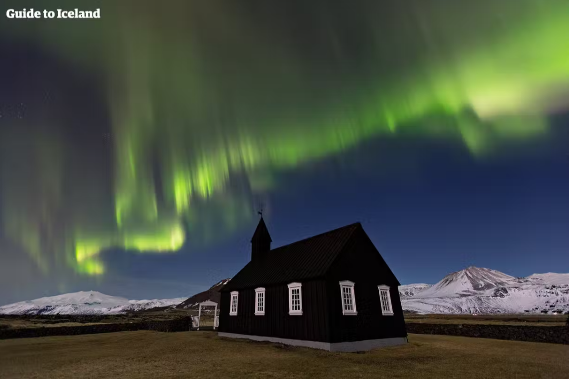 The Black Church of Budir with the northern lights and the Snaefellsjokull in the background.