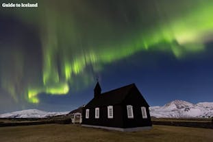 The Black Church of Budir with the northern lights and the Snaefellsjokull in the background.