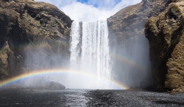 The powerful mist sprays of the Skogafoss waterfall projects a lovely rainbow across the scenery.