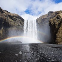 The powerful mist sprays of the Skogafoss waterfall projects a lovely rainbow across the scenery.
