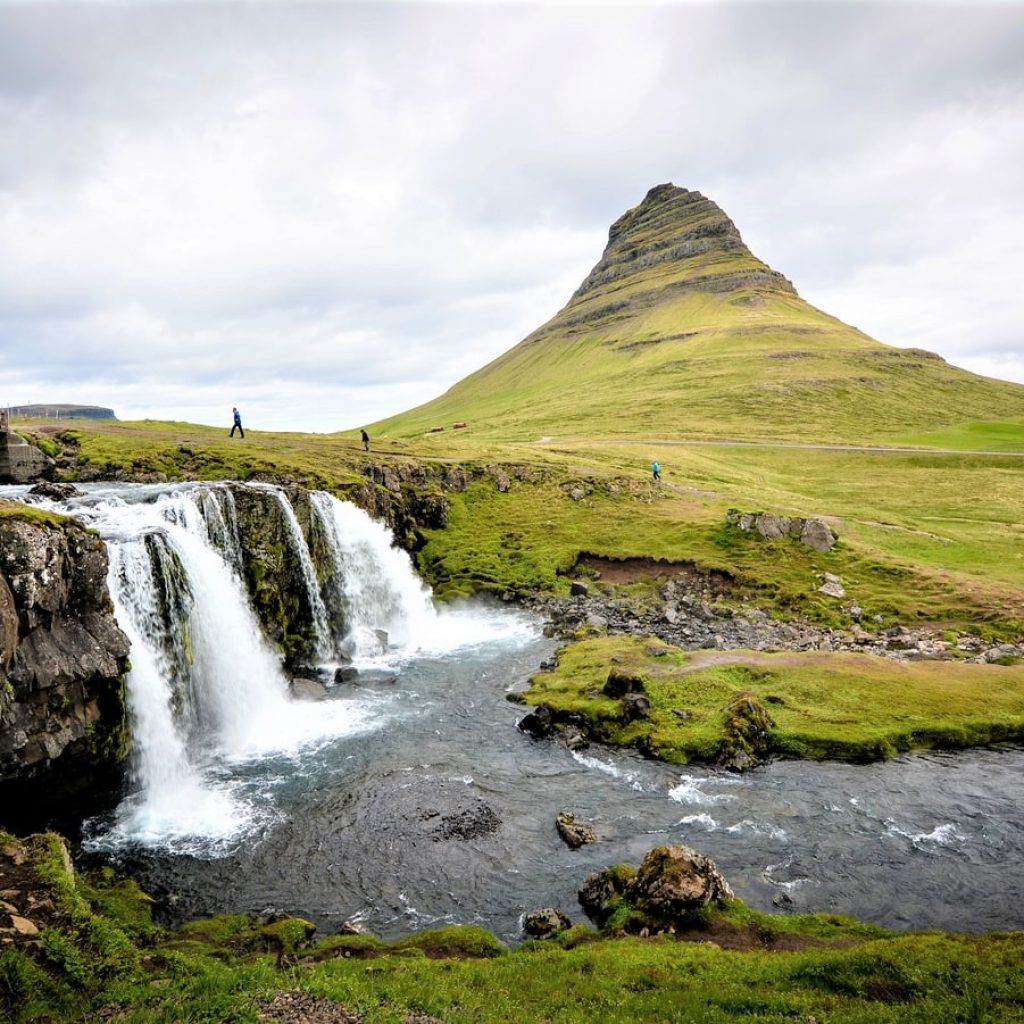 A small waterfall rushes before Mount Kirkjufell.