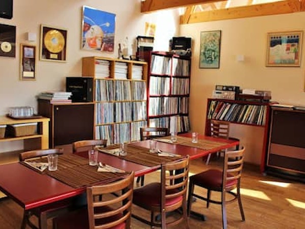 The table is laid in the restaurant dining area at Fossatun Country Hotel with the shelves stacked full of vinyl records behind.