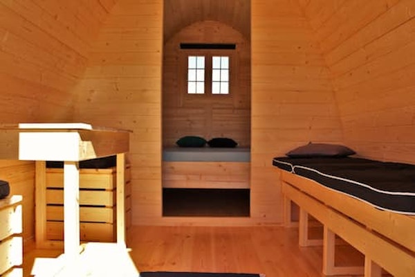 Beds and the wooden interior of a Fossatun camping pod.
