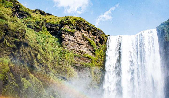 Beautiful rainbows curving through the powerful sprays of the Skogafoss waterfall.
