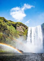 Beautiful rainbows curving through the powerful sprays of the Skogafoss waterfall.