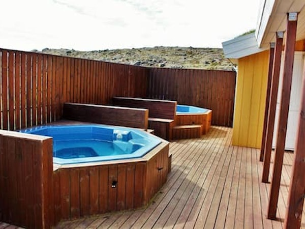 Two outdoor hot tubs on the patio at Fossatun Country Hotel.