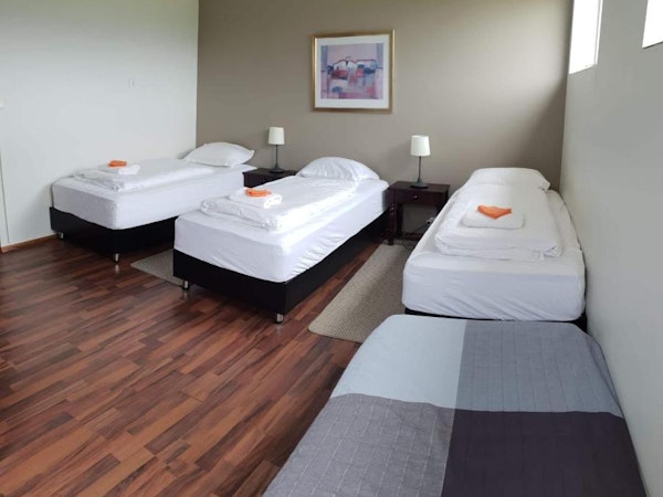 Guesthouse Hvita triple bedroom with three single beds.