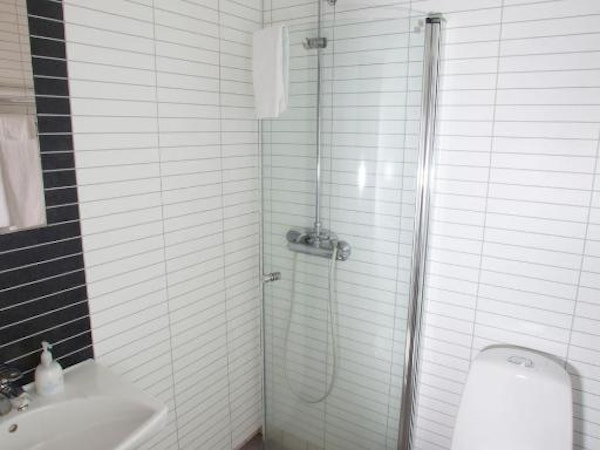 Hotel Borgarnes bathroom with toilet, shower, and sink.