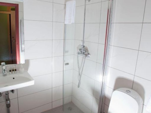 Hotel Borgarnes bathroom with shower, toilet, and sink.
