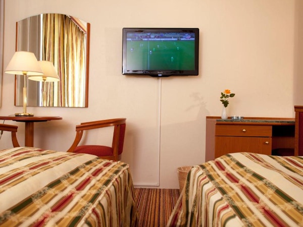 Hotel Borgarnes bedroom with TV and mirror.