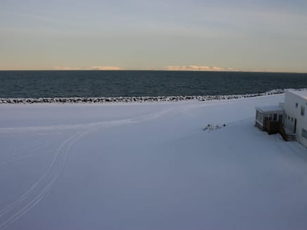 The waterfront near Hotel Keilir with the land covered in snow.