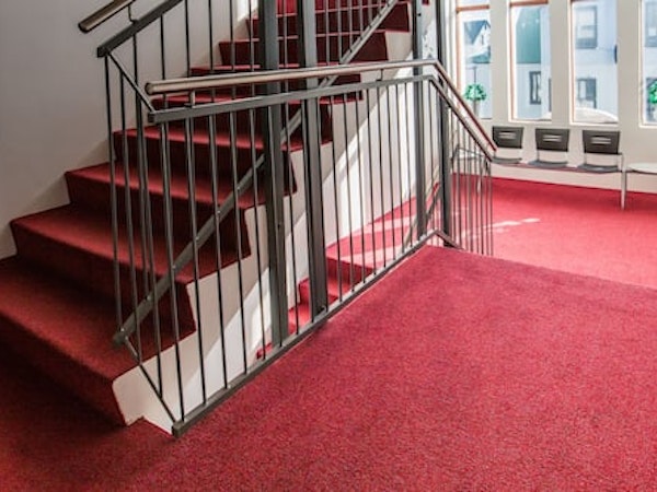 A staircase with red carpet at Hotel Keilir.