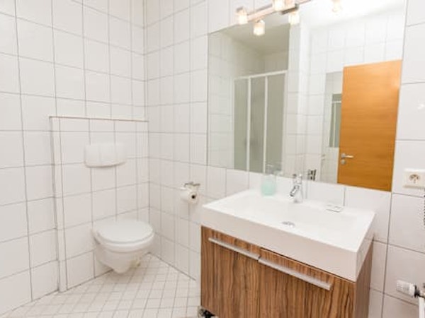 A bathroom with a basin, toilet, and mirror at Hotel Keilir.