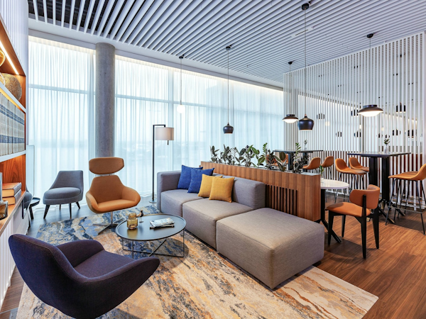 The lounge area with comfortable chairs and tables at the Courtyard by Marriott Reykjavik Keflavik Airport.