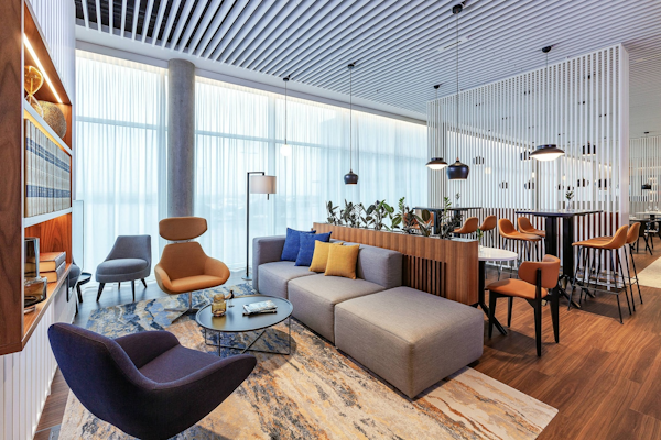 The lounge area with comfortable chairs and tables at the Courtyard by Marriott Reykjavik Keflavik Airport.