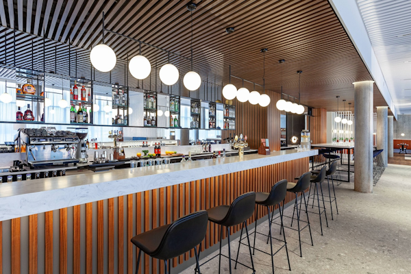 The bar area with barstools at the Courtyard by Marriott Reykjavik Keflavik Airport.