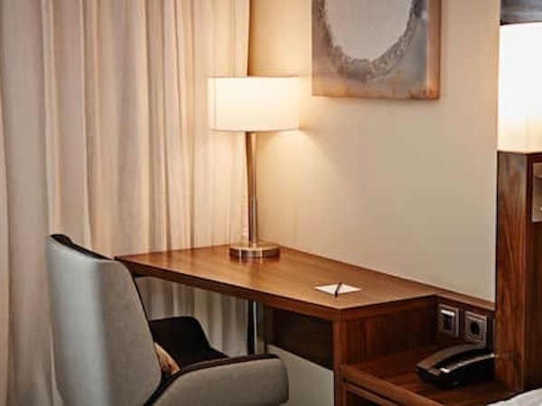 A desk, chair, and lamp in a room at the Courtyard by Marriott Reykjavik Keflavik Airport.
