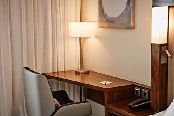A desk, chair, and lamp in a room at the Courtyard by Marriott Reykjavik Keflavik Airport.