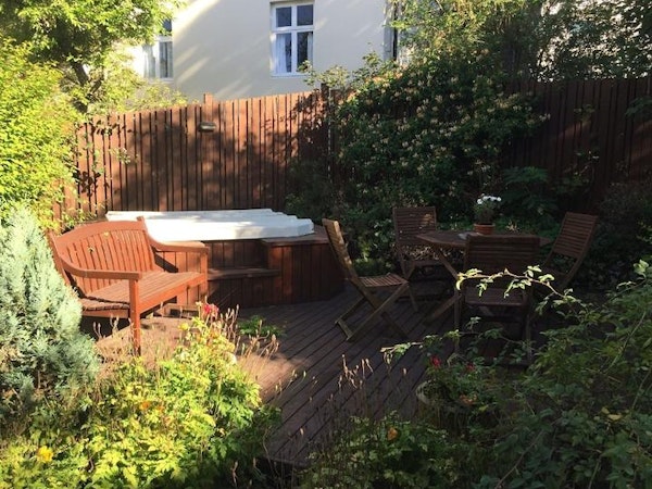 The lush garden of the Baldursbra Guesthouse features an outdoor sitting area and a hot tub/jacuzzi.