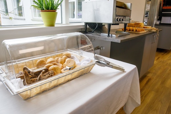 The breakfast buffet area with a toaster and fresh bread and pastries at Hotel Laugar Reykjadalur.