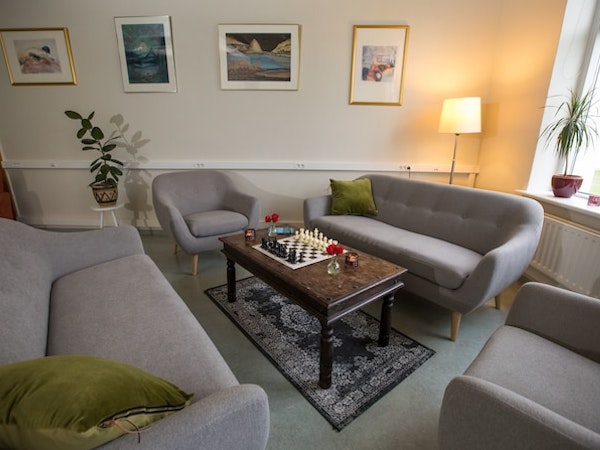 The tastefully designed lounge area with comfortable sofas and chairs and a table with a game of chess at Hotel Laugar Reykjadal