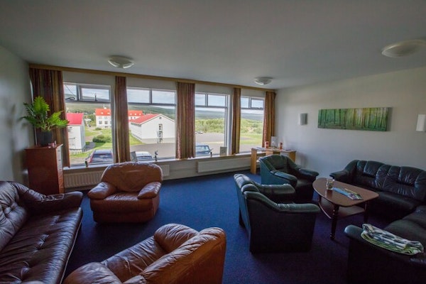A lounge area with comfortable leather chairs and tables at Hotel Laugar Reykjadalur.