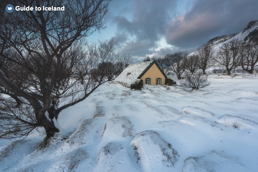 Hofskirkja turf church in Southeast Iceland amid a snow-covered landscape