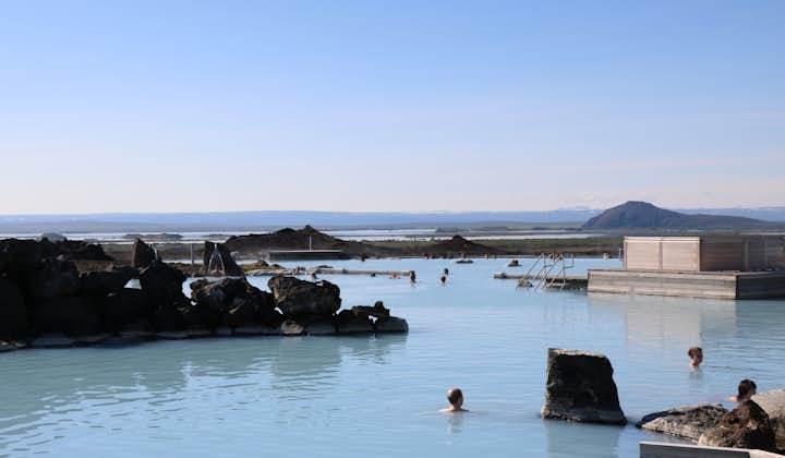 Mennesker svømmer i det blå mineralrike vannet i Myvatn Nature Baths.