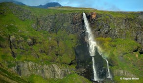 Bjarnarfoss waterfall's water cascading through black basalts. 