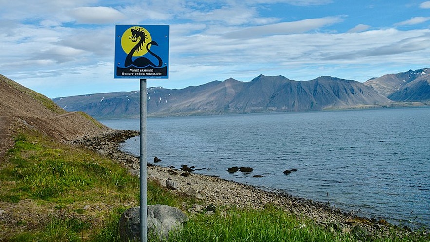 Znak ostrzegający przed potworami morskimi na brzegu fiordu Arnarfjordur na Fiordach Zachodnich.